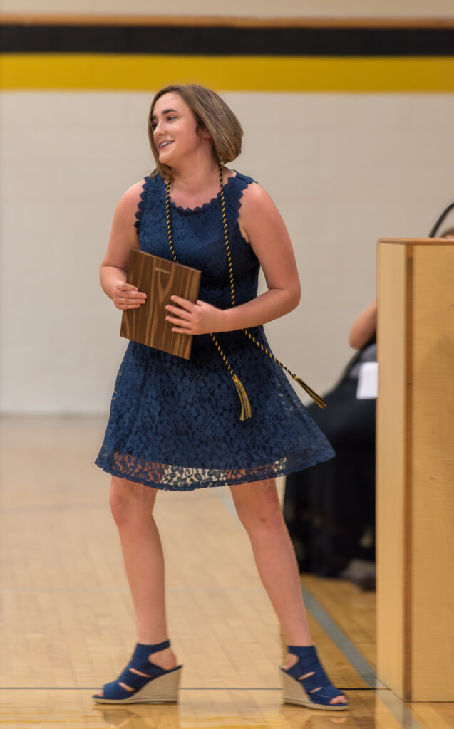 Girl in Dress After Accepting Plaque at Graduation