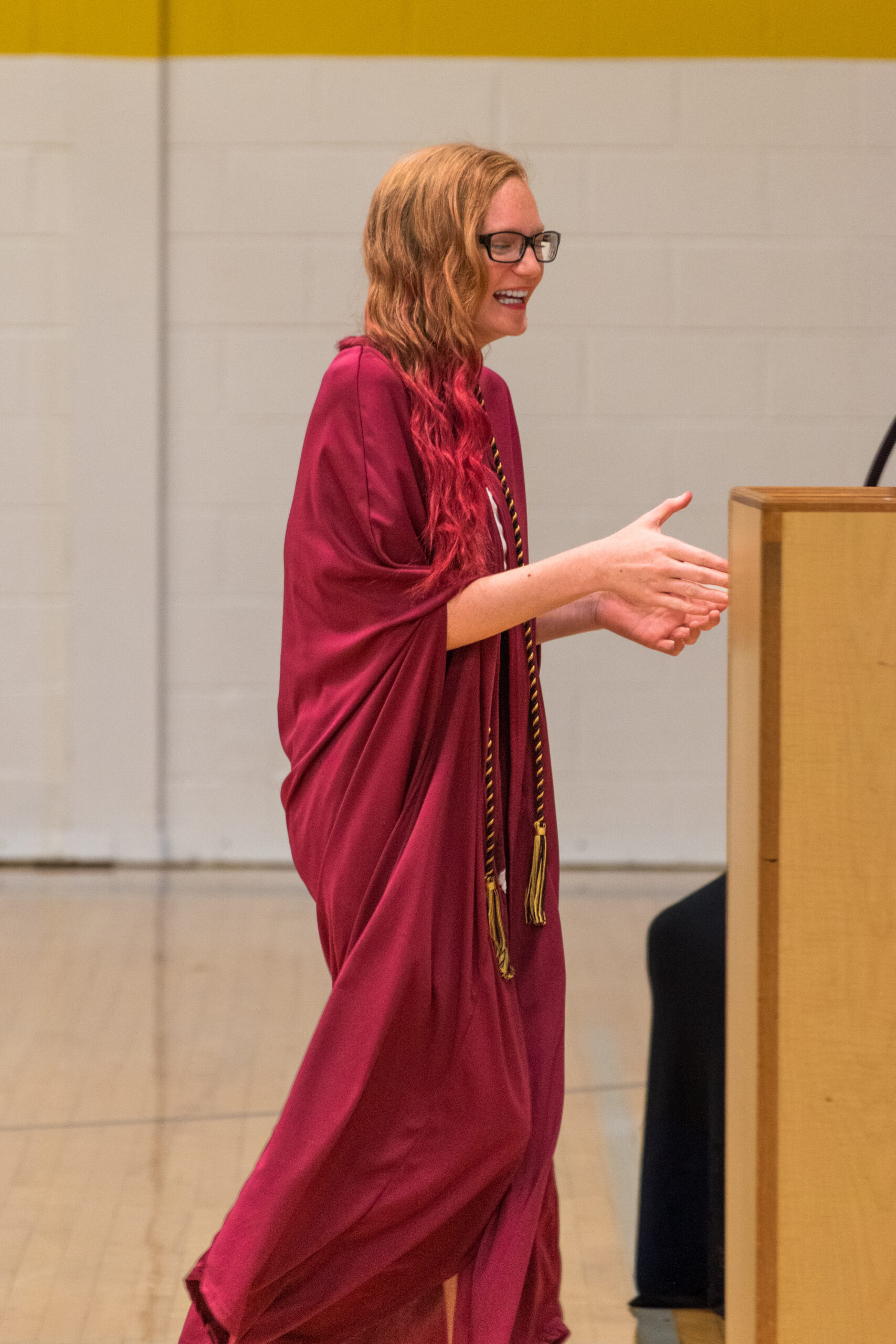 Chattanooga photographer graduation session — girl in a graduation gown reaching for her diploma.