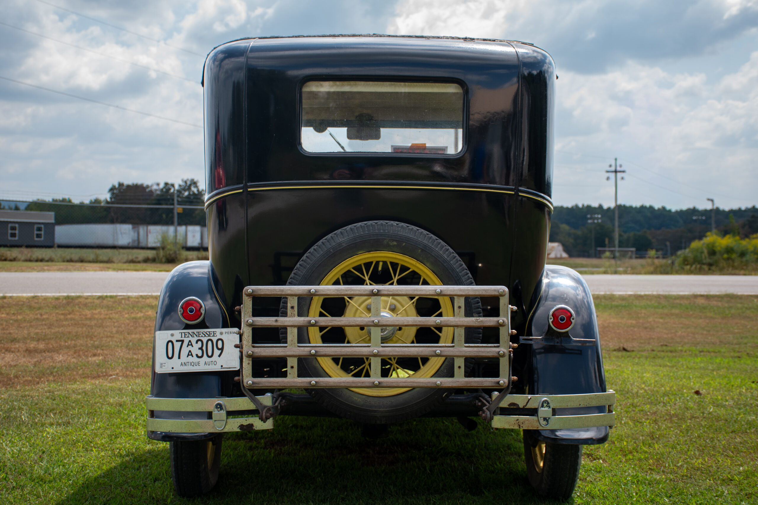 Classic car photography detail — rear profile of the Model A Ford with its spare tire and tail lamps.